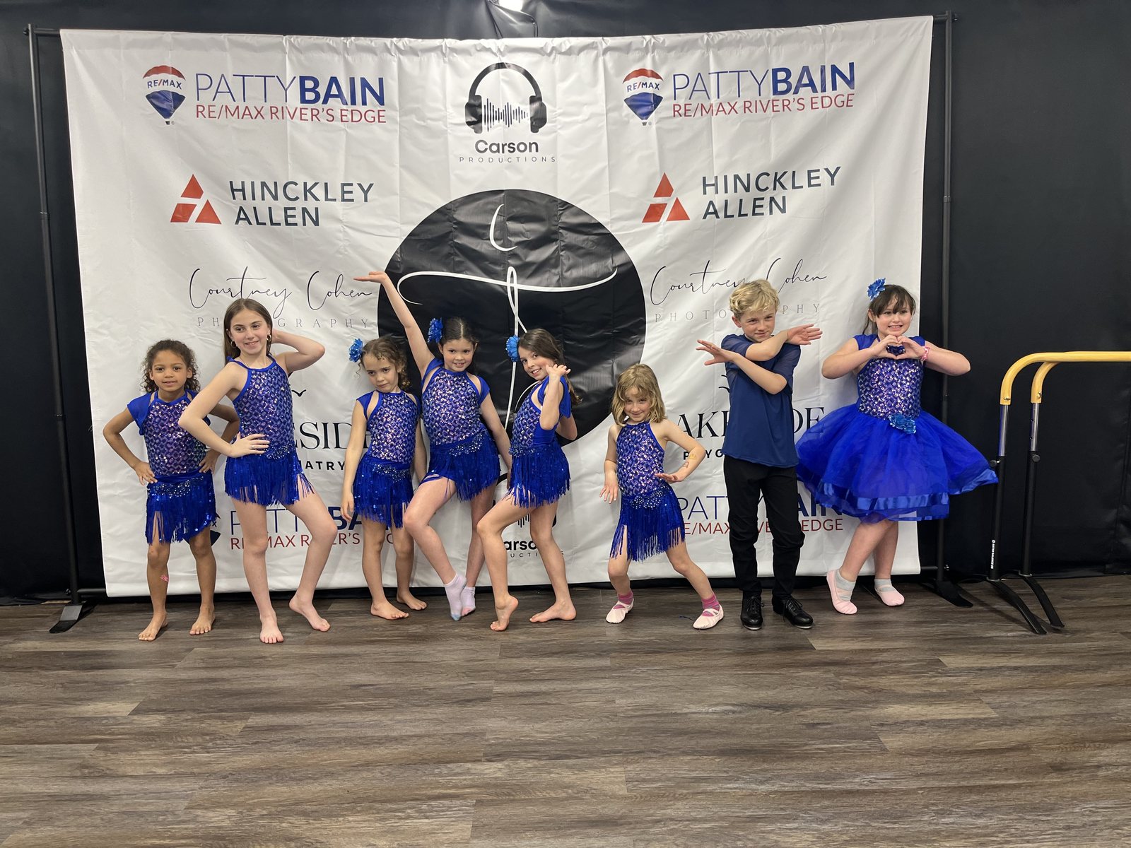 A group of young Empowered Movement dancers posing together in blue costumes